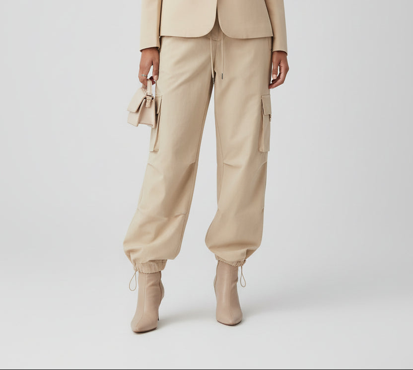 Woman wearing a beige suit with a plain background