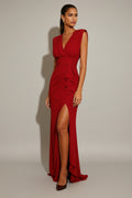 Woman wearing a red evening gown with a high slit on a white background