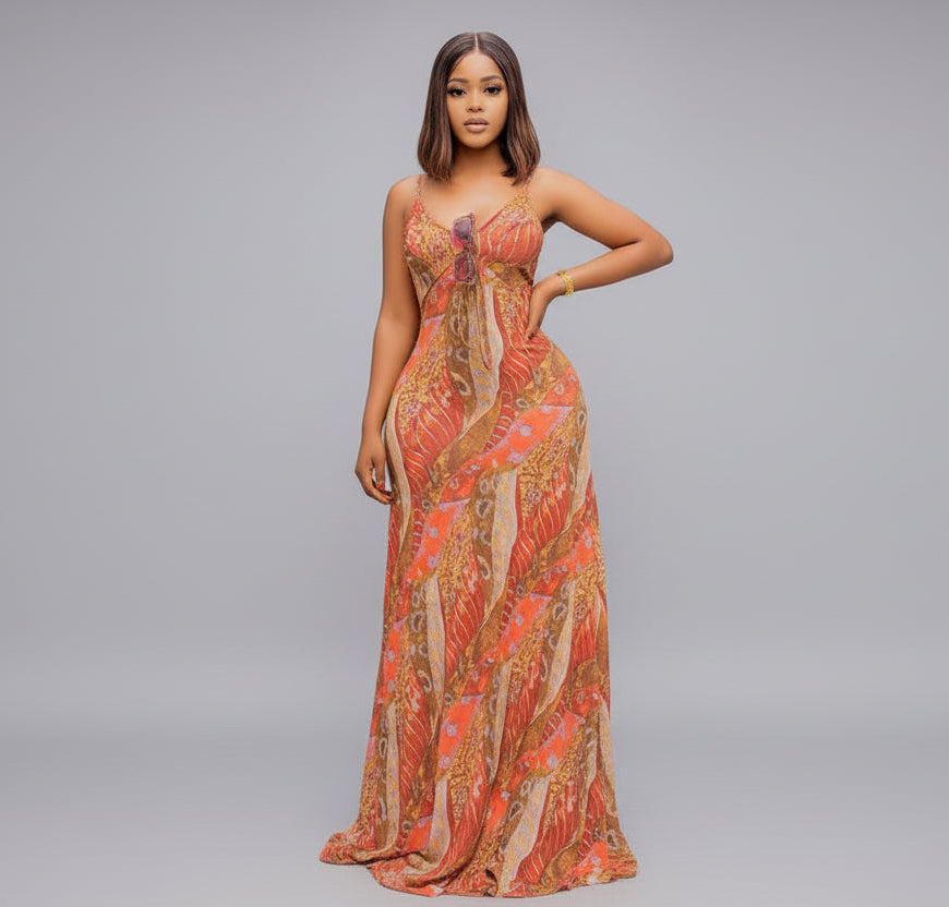 Woman wearing a patterned orange dress on a gray background
