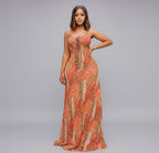 Woman wearing a patterned orange dress on a gray background