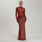 Woman wearing a long burgundy dress against a beige background