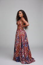 Woman in a colorful patterned dress standing outdoors.