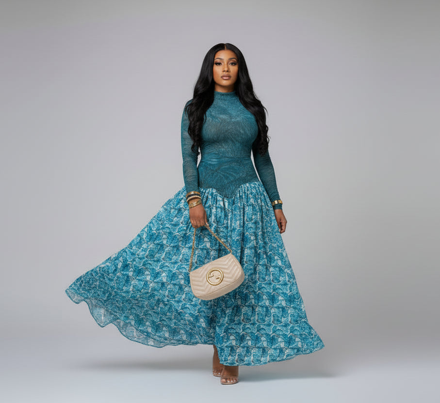 Woman in a blue patterned dress posing in a decorative interior setting