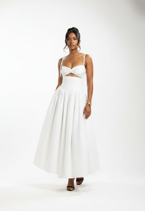 Woman wearing a white dress with cut-out design against a brown background