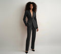 Woman wearing a gray suit against a plain background