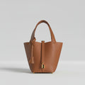 Brown leather handbag with gold accents on a white background