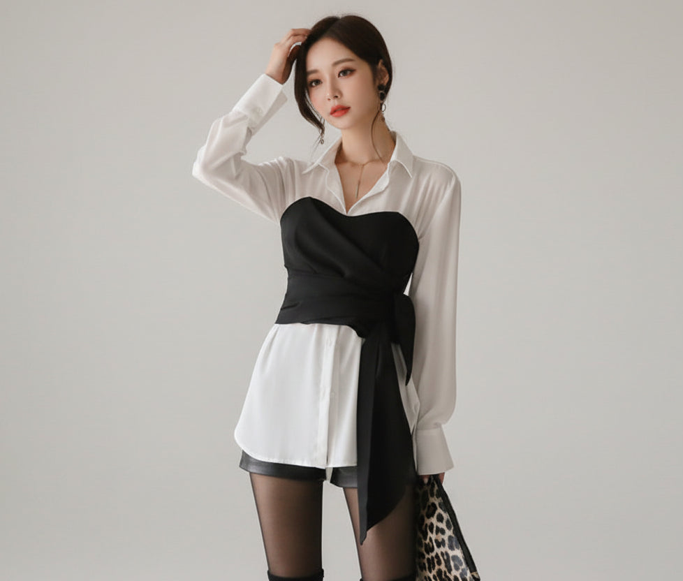 Woman wearing a black and white outfit with sheer stockings indoors.