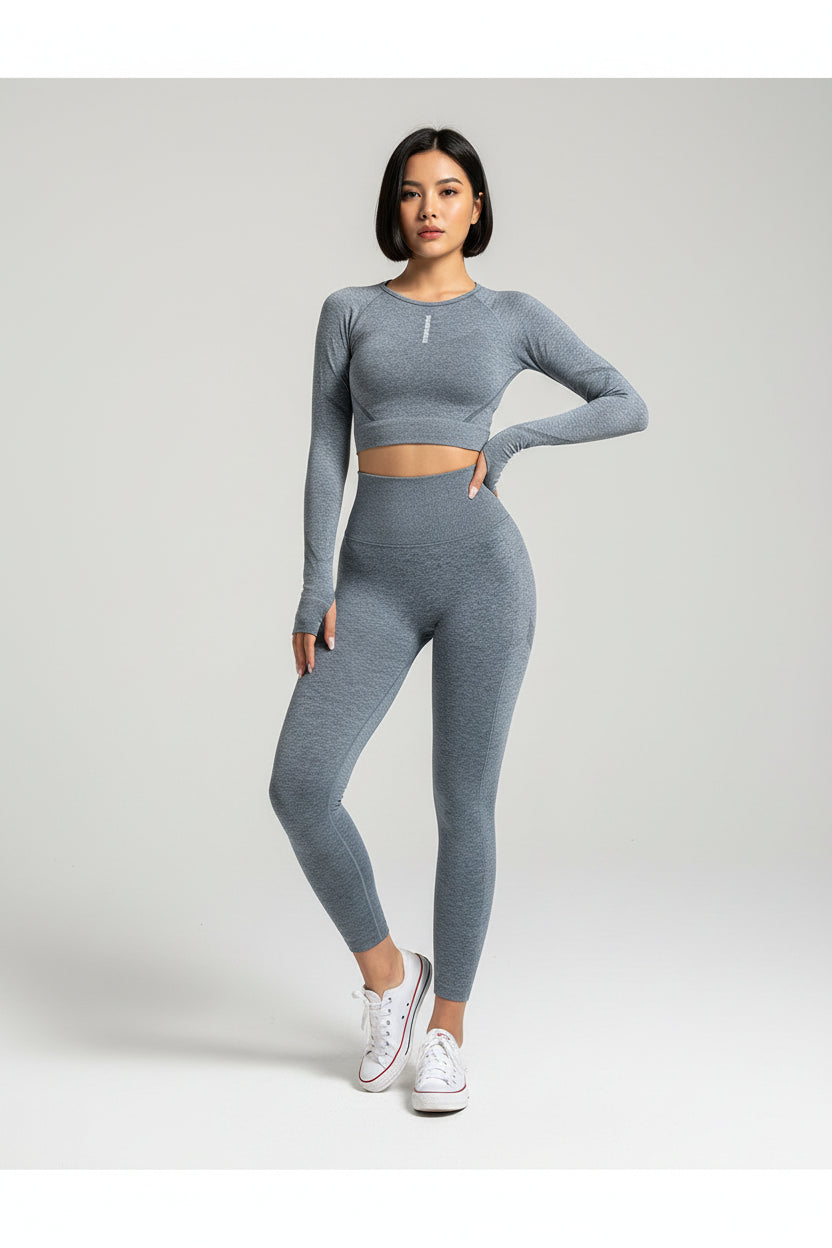 Person wearing a gray athletic outfit standing against a beige wall.