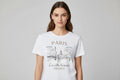 White t-shirt with Paris-themed design and text on a hanger.