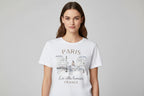 White t-shirt with Paris-themed design and text on a hanger.