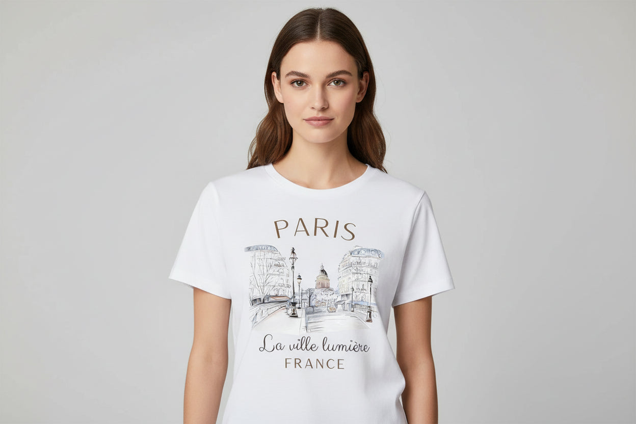White t-shirt with Paris-themed design and text on a hanger.