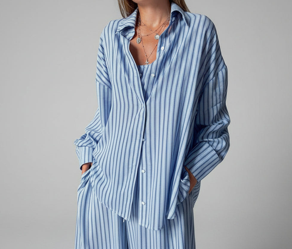 Person wearing a blue and white striped shirt and pants in a room.