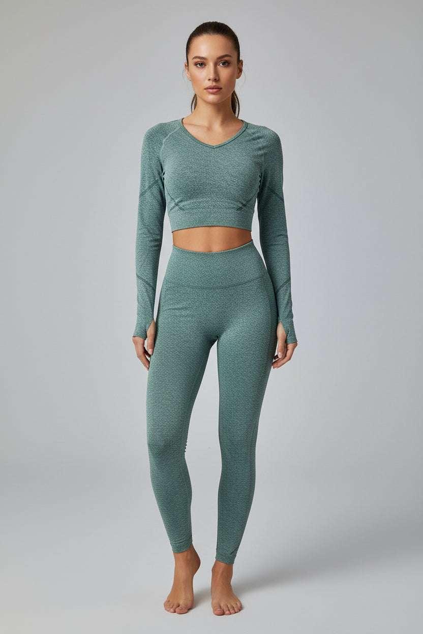 Green athletic outfit with long-sleeve top and leggings on a light gray background